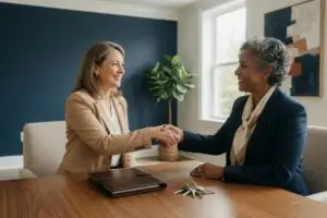 can i fire my realtor - homeowner shaking hands with a managing broker across a warm wood desk after agreeing a clean written release